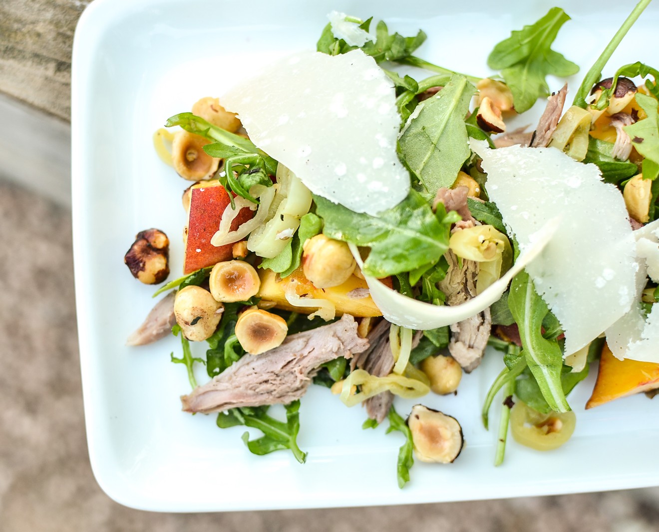 Texas peaches, braised duck, pickled peppers, chilies, hazelnuts, arugula and Parmesan grace this salad at Coltivare.