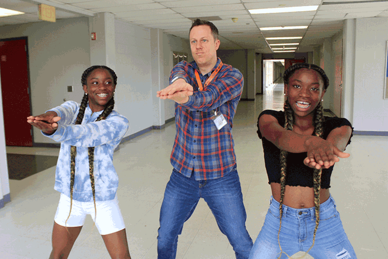Bellaire High School Spanish teacher, Trevor Boffone, Ph.D., busting a move with students Takia and Talia Palmer in 2019