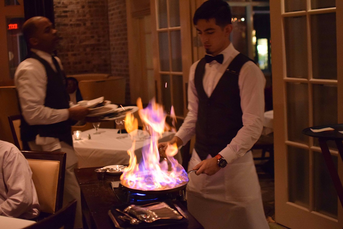 At the 50-year celebration of Brennan's of Houston, a server wows guests with bananas Foster prepared at the table-side.