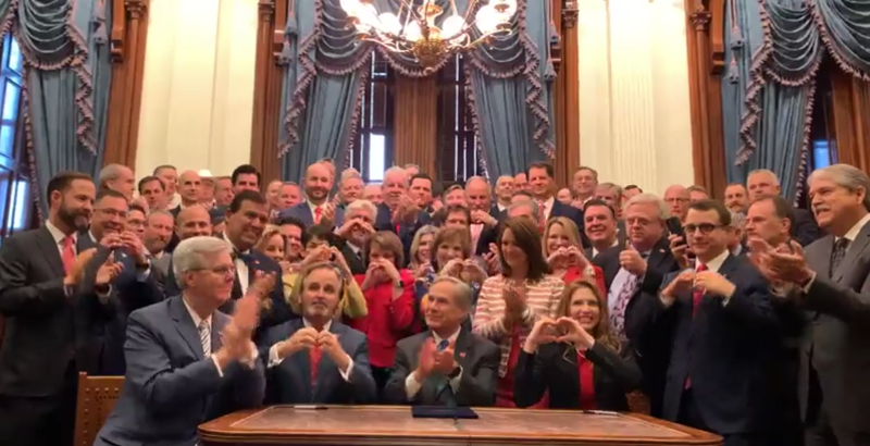 Giddy anti-abortion lawmakers made "heartbeat" hand signs moments after Gov. Greg Abbott signed Senate Bill 8 Wednesday morning.