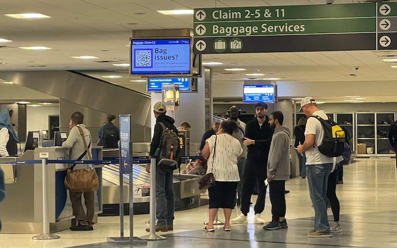 Passengers line up at George Bush Intercontinental Airport's baggage claim walk in line to talk to an employee for help with finding their bags amid baggage arrival delays.