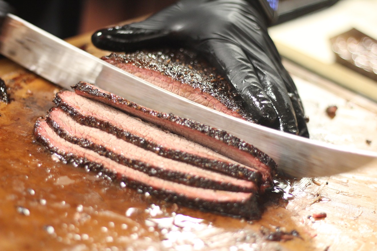 Chef Ara slices tender, juicy beef brisket for orders at Harlem Road Texas BBQ