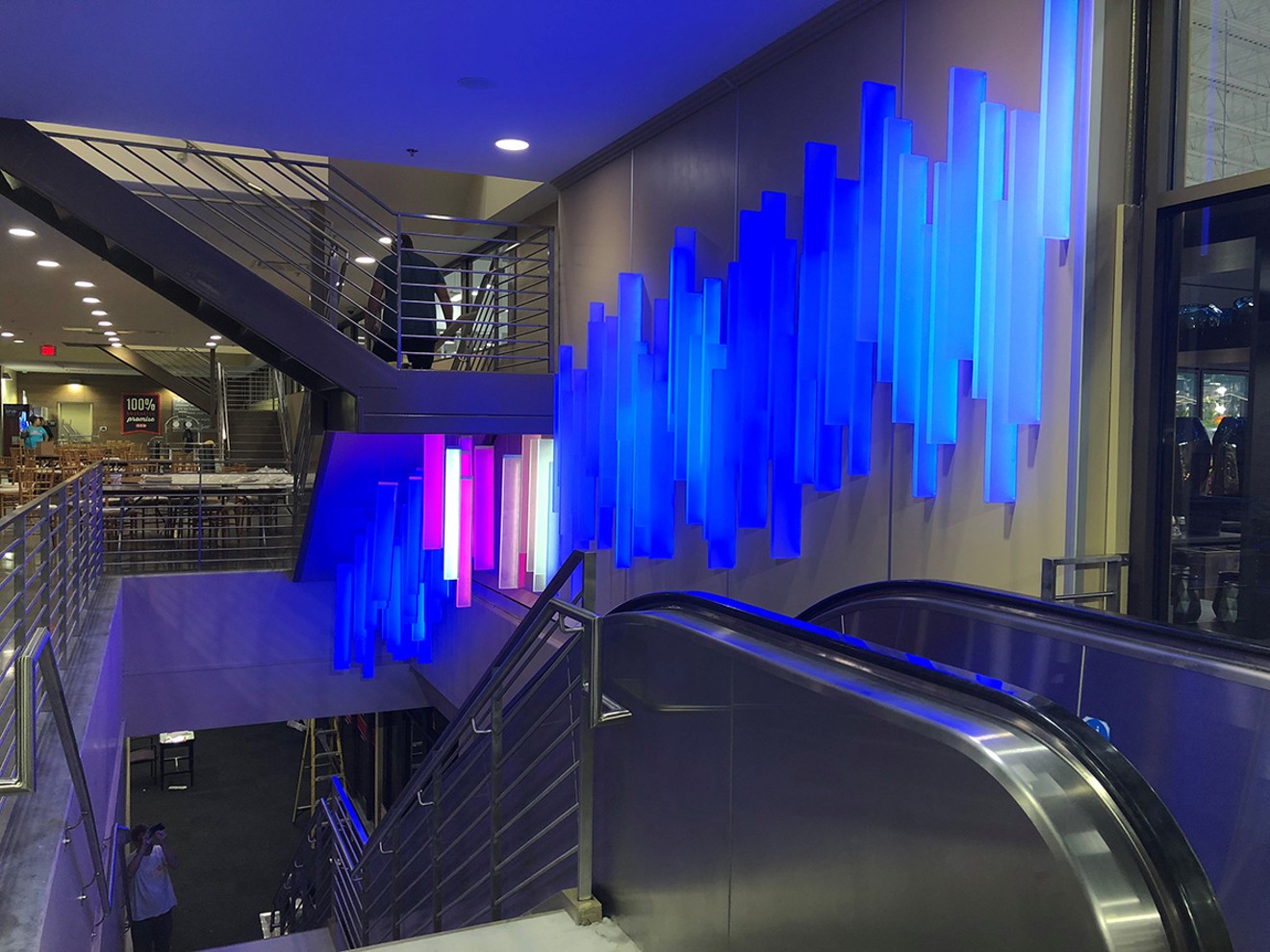 "Blue by You" by Ansen Seale is a permanent installation at the new multi-story H-E-B Bellaire Market at 5106 Bissonnet. As shoppers pass by on the upstairs level, walk down the stairs or go up the escalator, their movement causes the colors to change.