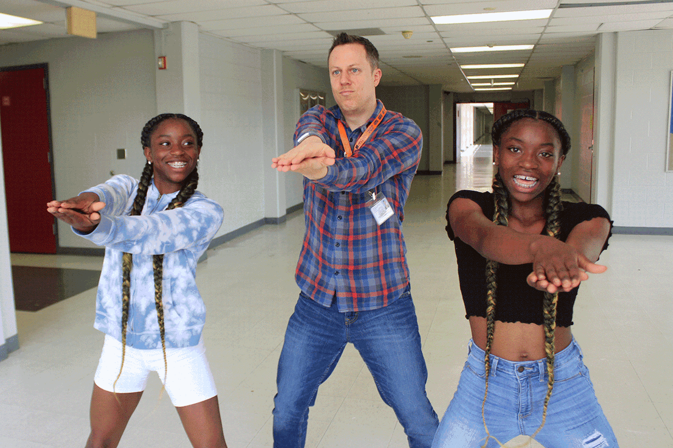 Bellaire High School Spanish teacher, Trevor Boffone, Ph.D.,  busting a move with students Takia and Talia Palmer.