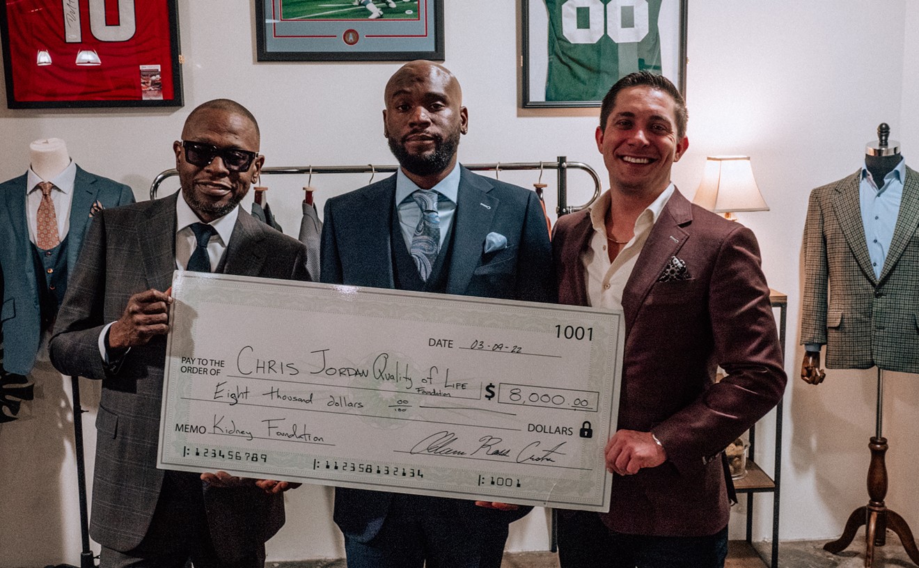 Scarface supports his son Chris Jordan as he accepts a donation from Adam Ross for the Chris Jordan Quality of Life Foundation.