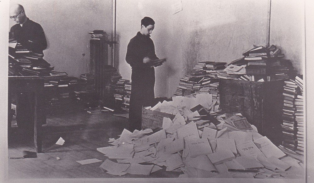 Mikhal Kovner, brother of Partisan Abba Kovner, sorting books; Vilna, 1943
