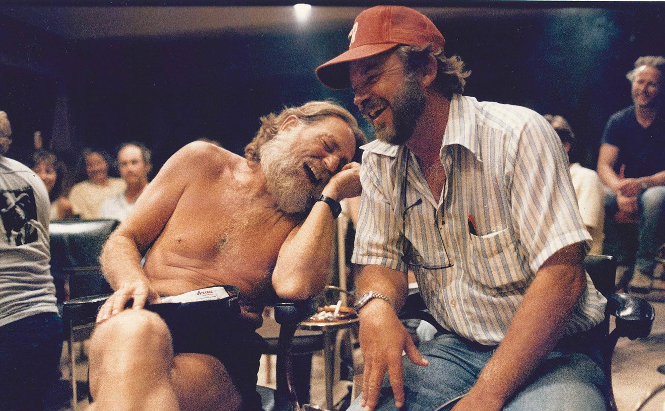 Willie Nelson leans on old friend Bill Wittliff on a movie set.