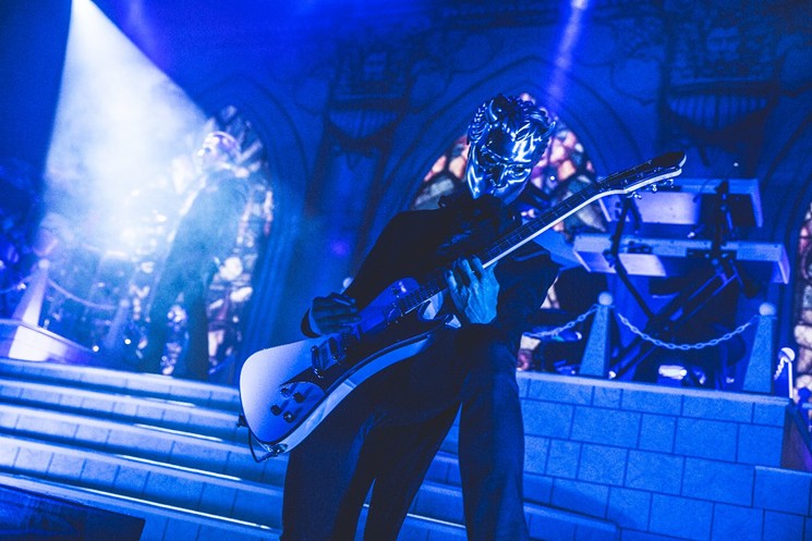 A nameless ghoul squeals the guitar while Copia stands atop the stage at Revention Music Center. - PHOTO BY DEREK RATHBUN