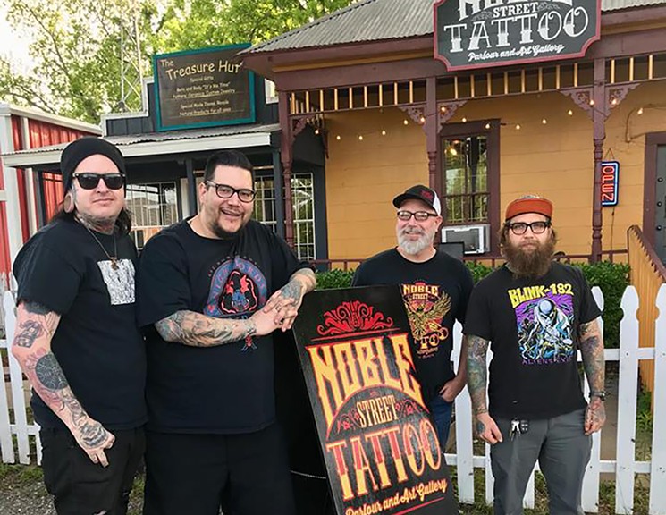 On opening night, the owner of Noble Street Tattoo Parlour (third from left) thought somebody had been trapped inside the bathroom. Nobody was found inside the hook and latch locked room with bars on its window. - PHOTO COURTESY OF NOBLE STREET TATTOO PARLOUR