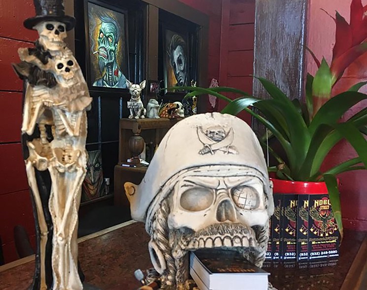 Noble Street also is an art gallery. See that pointy-eared dog sculpture in the background? Be it spirits, poltergeists or unexplainable phenomena, he keeps getting knocked to the ground. - PHOTO COURTESY OF NOBLE STREET TATTOO PARLOUR