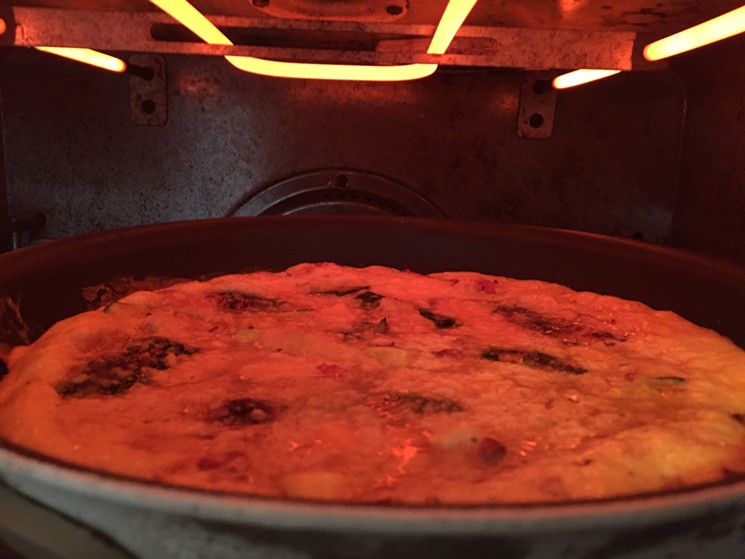 A frittata of leftover parmigiano-roasted zucchini with salami, onion and cheddar, in its final moments under the broiler. - PHOTO BY NICHOLAS L. HALL