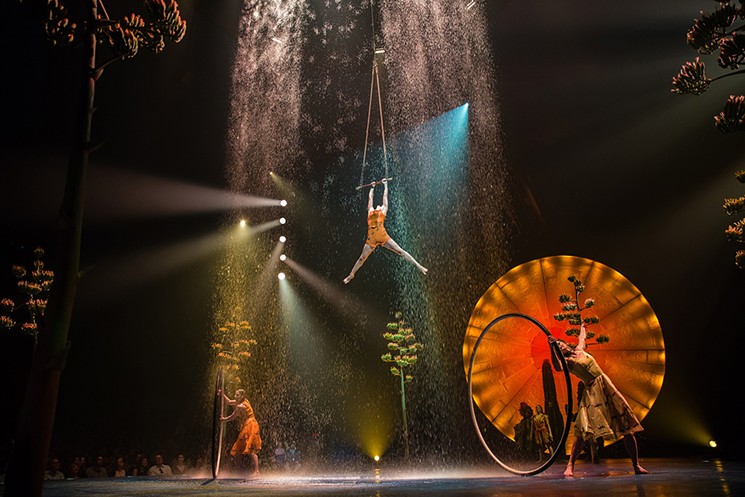 The cyr wheel and trapeze act incorporates a setting sun, quiotes (agave) plants and a rain shower. Shown: Roue Cyr and Trapeze, costumes by Giovanna Buzzi / 2016 Cirque du Soleil - PHOTO BY MATT BEARD