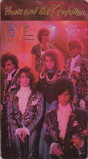This VHS tape of a 1985 show featured Prince and the Revolution during their frilly heyday: (clockwise from bottom left) Wendy Melvoin, Bobby Z, Dr. Matt Fink, Brownmark, Prince. Lisa Coleman is in the center. - VHS CASSETTE COVER. WARNER MUSIC GROUP/PAISLEY PARK