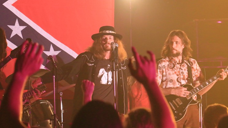 Taylor Clift (as singer Ronnie Van Zant) and Samuel Kay Forrest (as guitarist Steve Gaines) perform in the film. Attention to detail: Clift's Neil Young T-shirt is a replica of the one the singer actually wore. Despite the barbs traded in Young's "Southern Man" and Lynyrd Skynyrd's response "Sweet Home Alabama," the musicians actually respected each other. - SCREEN GRAB/COURTESY OF CLEOPATRA ENTERTAINMENT