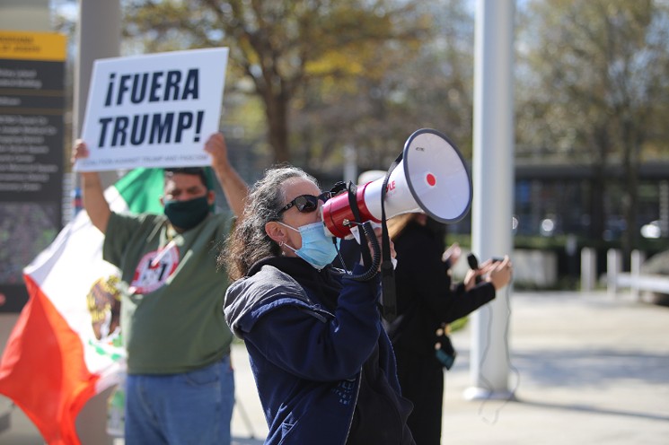 A woman took to the bullhorn in front of the Mickey Leland Federal Building Thursday. - PHOTO BY DOOGIE ROUX