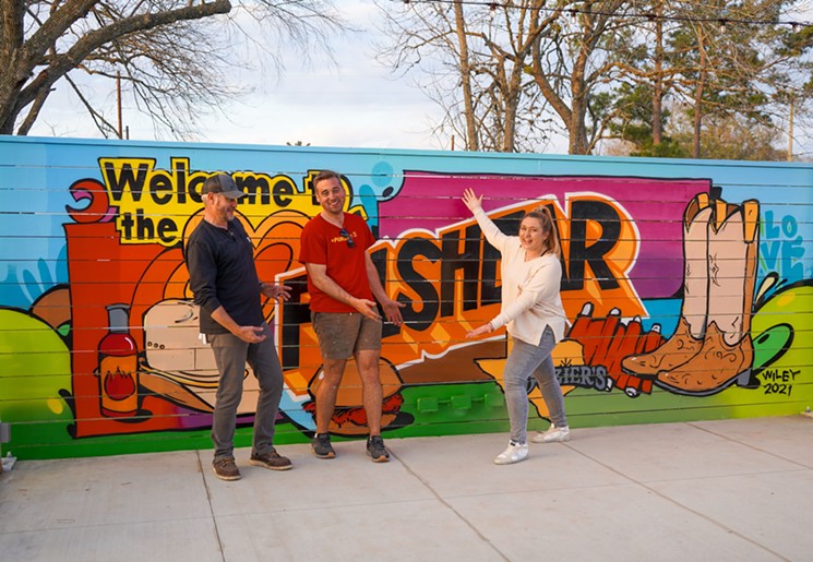Pitmaster Buchanan, artist Wiley Robertson and graphic designer Kathryn Hinnant stand in front of the new mural. - PHOTO BY KATHRYN HINNANT