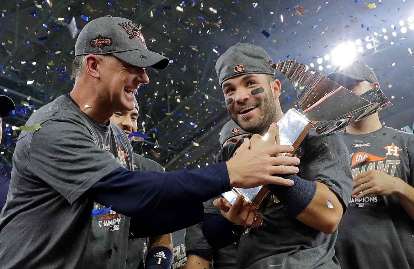 Astros second baseman Jose Altuve hugs the American League Championship trophy with manager A.J. Hinch after they won the pennant over the New York Yankees.