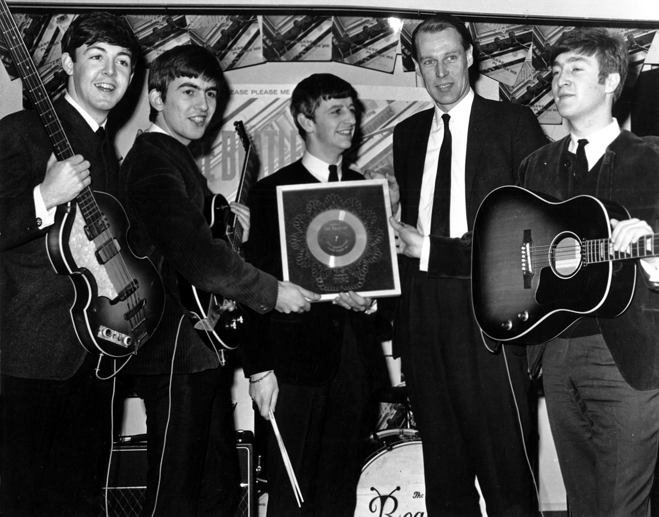 George Martin (second from right) and the Beatles pose with gold discs. In 1963 alone, Martin's acts held the No. 1 spot on the UK charts for 37 weeks.