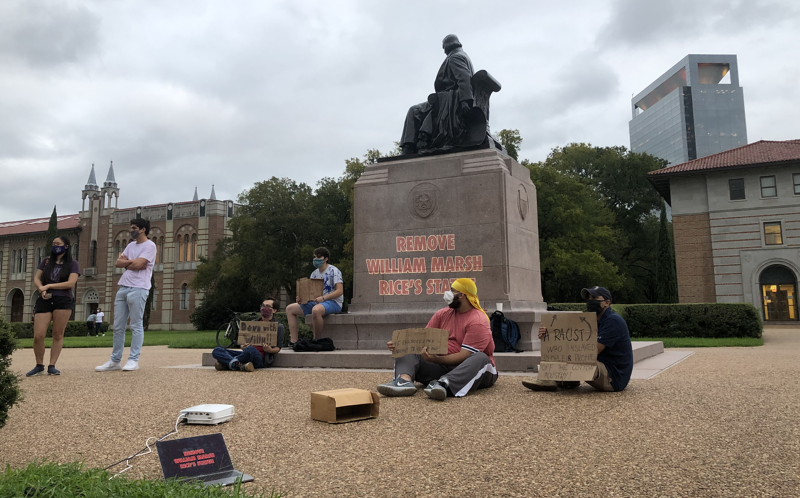 Students protest the statue of William Marsh Rice in the university's main quad.